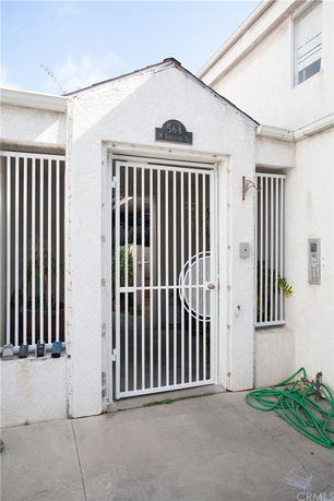 Front view of a building entrance with a metal gate and security features.