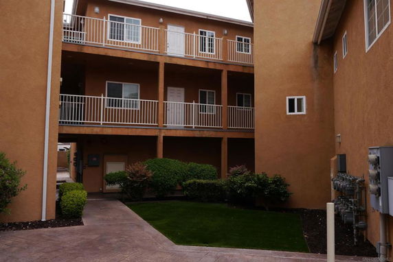 Front view of a multi-story apartment building with balconies.