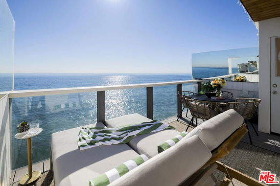 Deck area with lounge chairs and table offering a panoramic ocean view