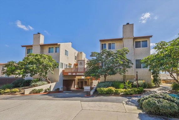 Front view of a two-story residential building with garages and chimneys.