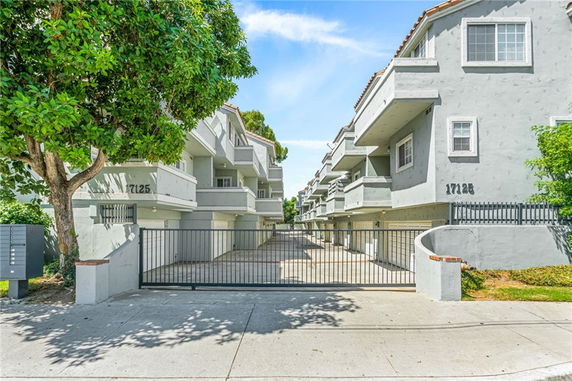Front view of a multi-story apartment building with gated parking.
