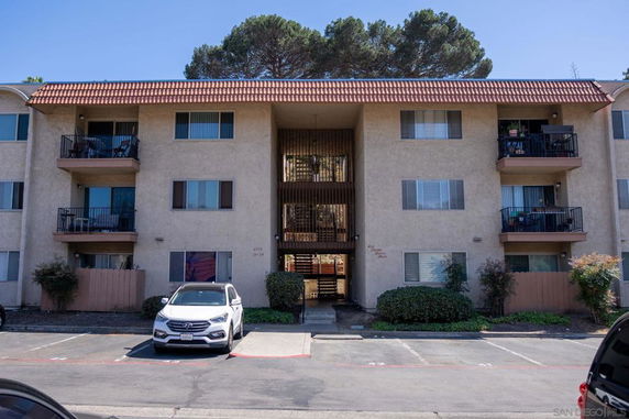 Front view of a multi-story apartment building with balconies.