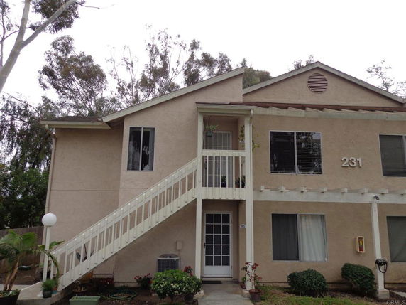 Front view of a two-story residential building with an exterior staircase.