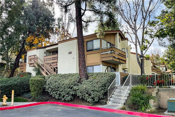 Front view of a two-story residential building with balconies and stairs.