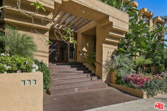 Front view of a building entrance with steps and decorative overhang.