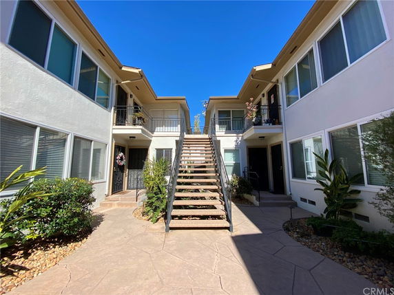 Front view of a multi-story residential building with an external staircase.