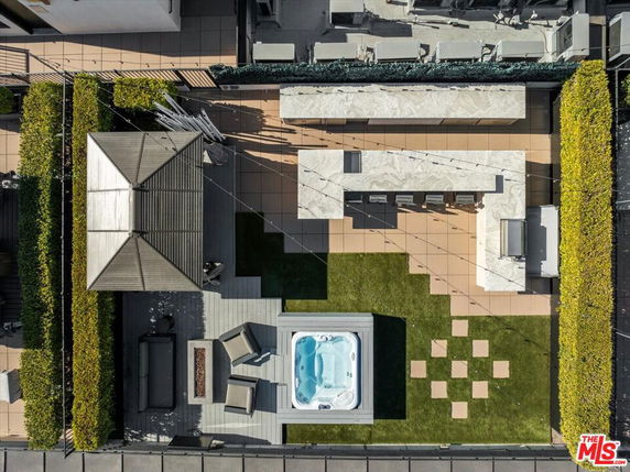 Aerial view of a rooftop with a seating area, jacuzzi, and outdoor kitchen setup.