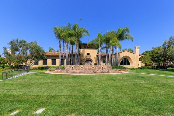 Front view of a large single-story house with arched windows and red-tile roof.