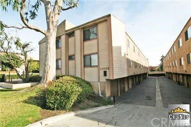 Front view of a multi-story apartment building with a driveway.