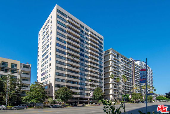Front view of a tall multi-story apartment building with balconies.
