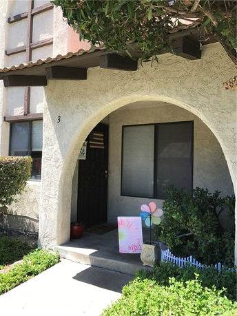 Front view of a house with an arched entrance and wooden beams.