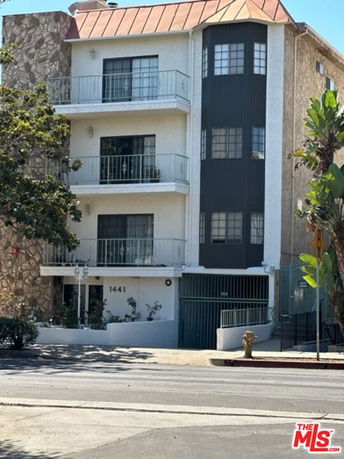 Front view of a multi-story residential building with balconies and garage.