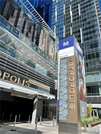Front view of a modern high-rise building with a prominent entrance sign labeled 'Metropolis'.