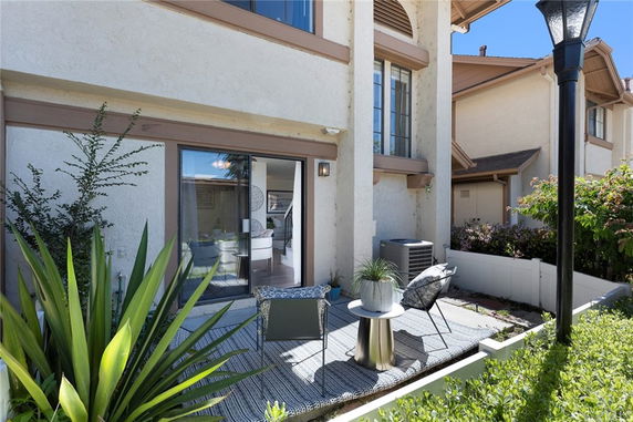 Front view of a multi-story house with a small patio area.