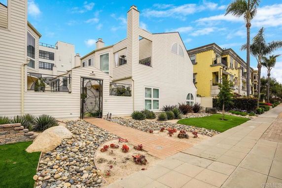 Front view of a multi-story house with a gated entrance.