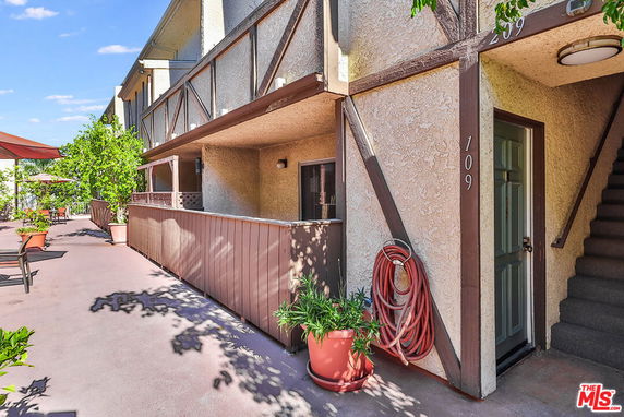 Front view of a multi-level residential building with an exterior walkway and door marked 109.
