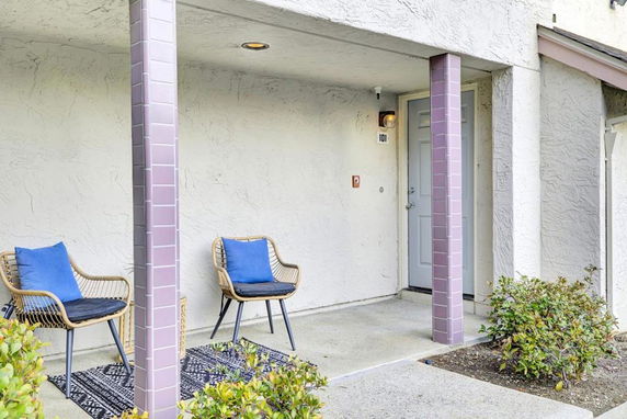 Front view of a house entrance with two chairs on a small porch.
