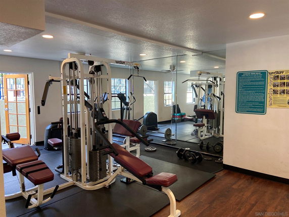 Indoor gym area with exercise equipment and mirrored walls.
