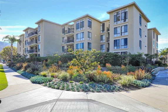 Front view of a multi-story apartment building with large windows and balconies.