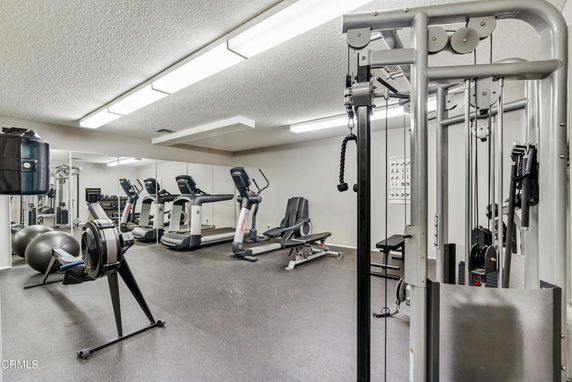 Indoor gym area with exercise equipment and mirrors.