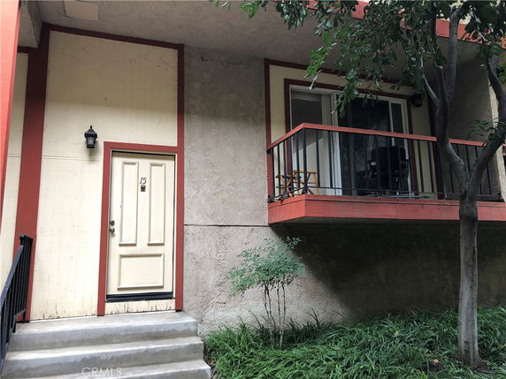 Front view of a building with a door and balcony.