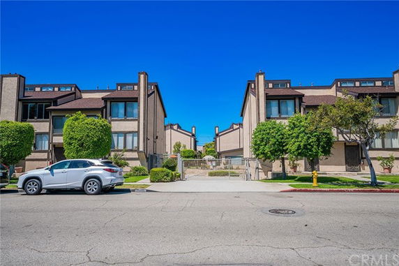 Front view of a multi-story residential complex with gated entrance.