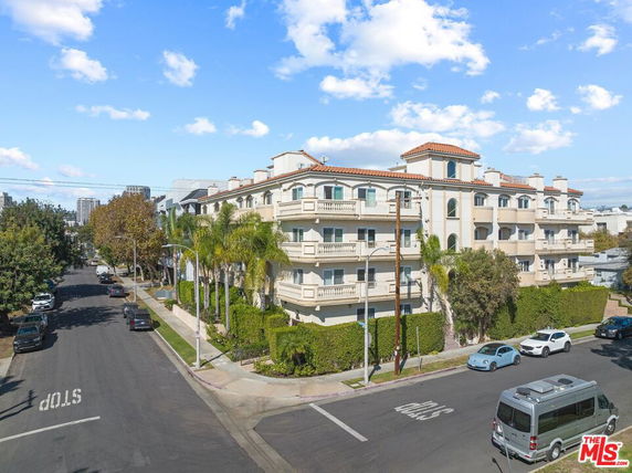 Front view of a multi-story apartment building on a street corner.