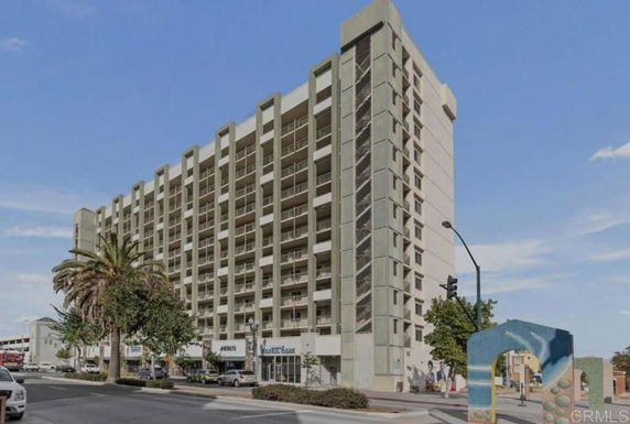Front view of a multi-story apartment building with balconies.