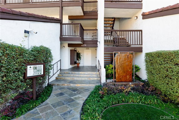 Entryway of a multi-story residential building with stairs and balconies.