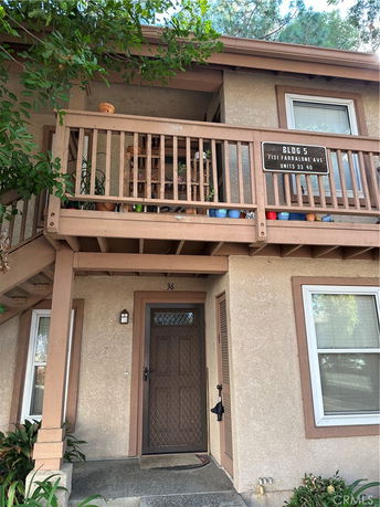 Front view of a two-story building with a small balcony and doorway.