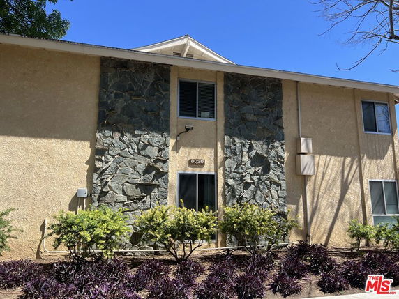 Front view of a two-story building with stone and stucco facade.