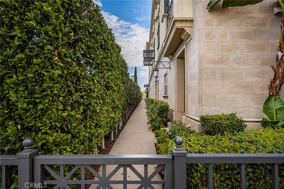 Side view of a multi-story building with a pathway and hedges.