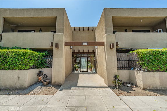 Front view of a multi-story building entrance with balconies.