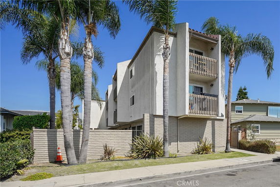 Front view of a modern multi-story apartment building with balconies.