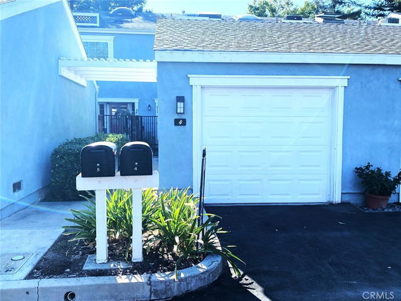 Front view of a house with a garage and mailboxes.