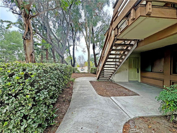 View of a building with an exterior staircase and a walkway.