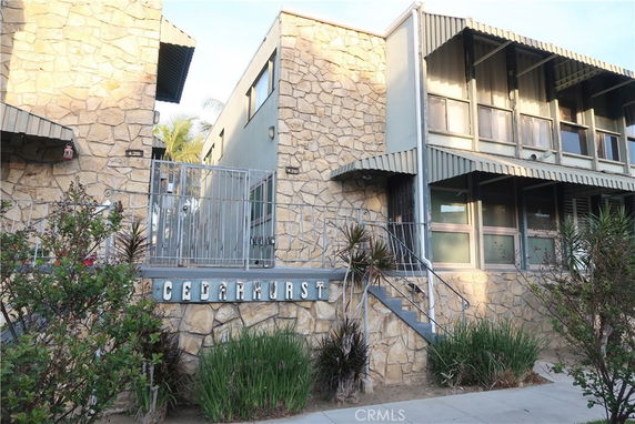 Front view of a two-story building with stone exterior and gated entrance.