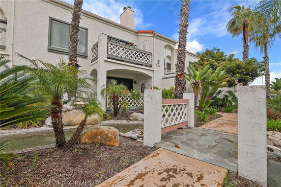 Front view of a two-story house with balconies and decorative railing.