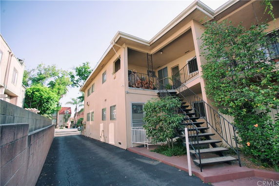 Front view of a multi-story apartment building with external staircases.