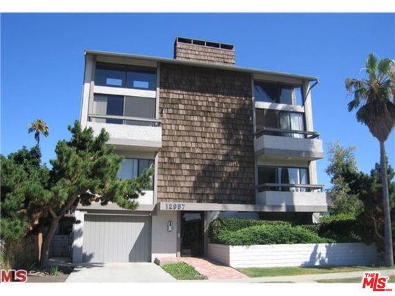 Front view of a multi-story building with a shingle facade and balconies.