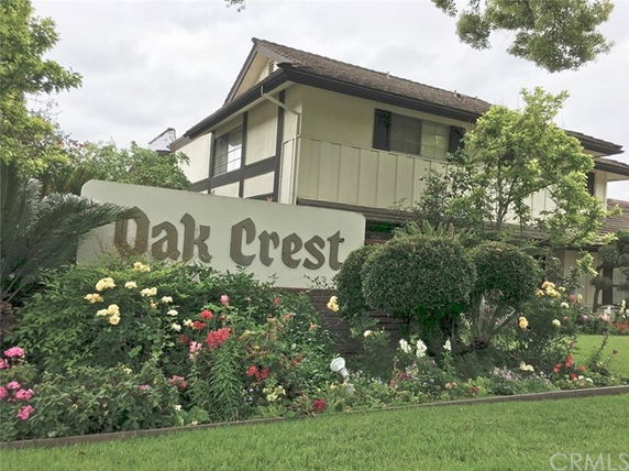Front view of a two-story building with a sign 'Oak Crest'.