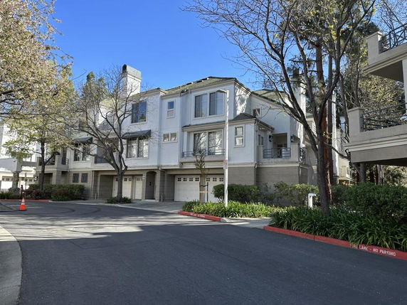 Front view of a multi-story building with garages on the ground floor.