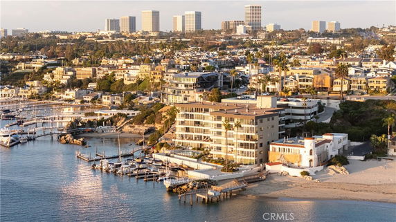 Aerial view of a coastal area with residential buildings and a marina with boats.