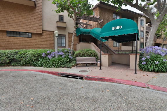 Front view of a multi-story building with a green awning above the entrance.