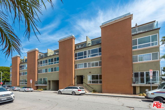 Front view of a multi-story building with large windows and balconies.