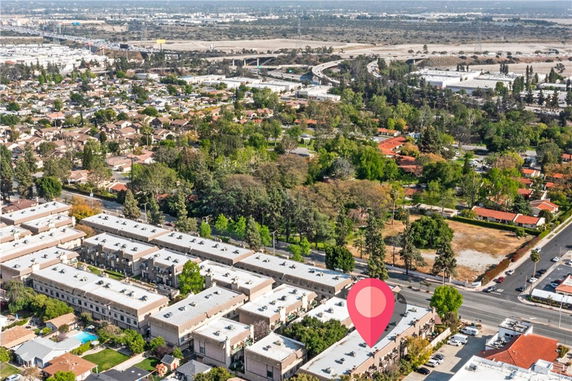 Wide aerial view of a residential area with multiple buildings and greenery.