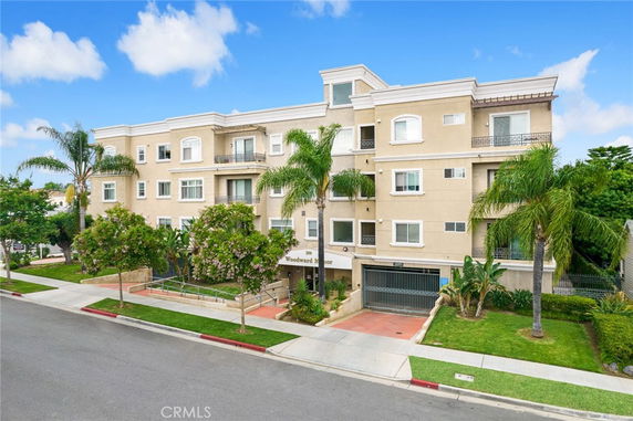Front view of a multi-story residential building with balconies and garage entrance.