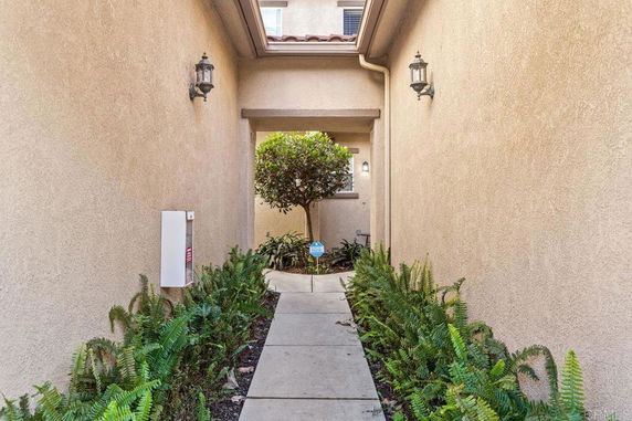 Front view of a narrow entrance path leading to a house.