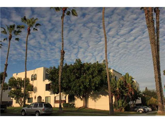 Front view of a multi-story building with palm trees nearby.