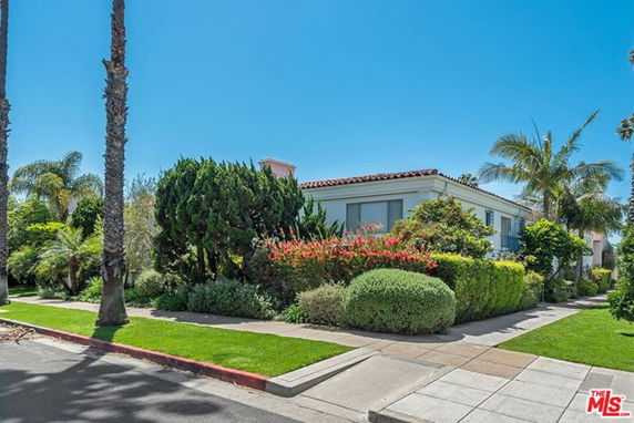 Front view of a single-story house with surrounding greenery.